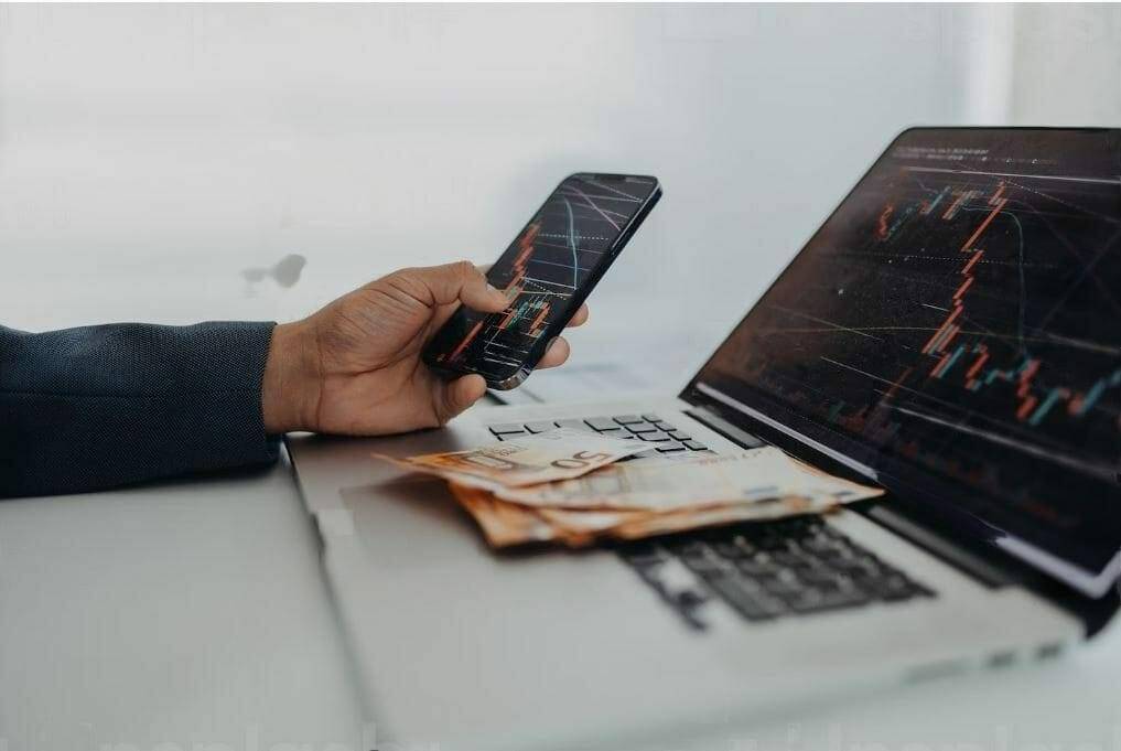 crypto trader on phone and laptop