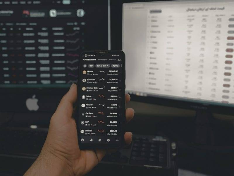 Two desktops and one mobile screen showing crypto exchanges and trends. 